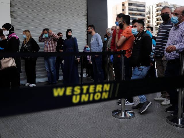 Customers queuing outside a Western Union money transfer location